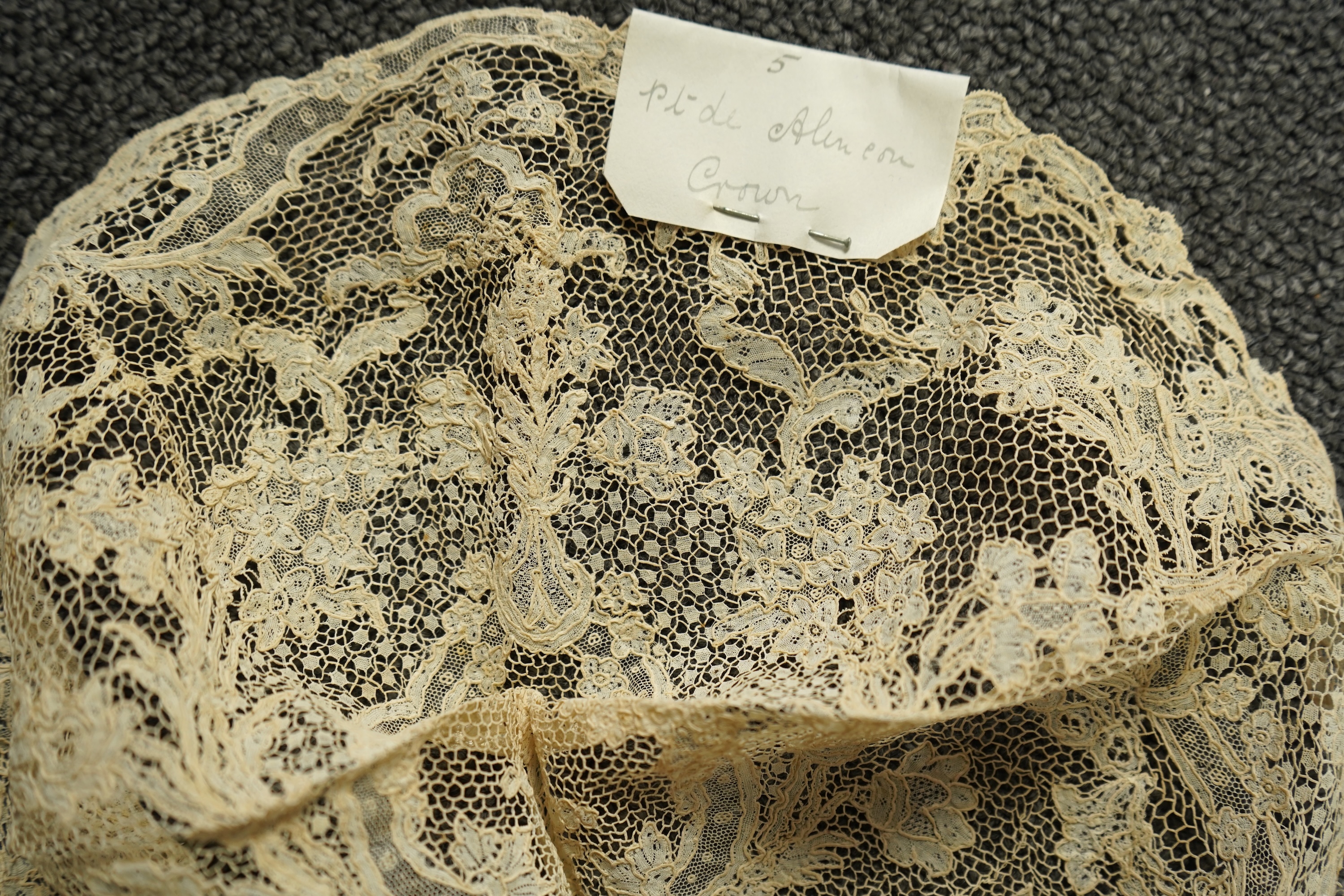 A collection of 18th century needle and bobbin lace. Including an 18th century wide pair of joined Valenciennes lace lappets, a similar 18th century cap back, an ornately worked Point de Alencon cap crown and another sim
